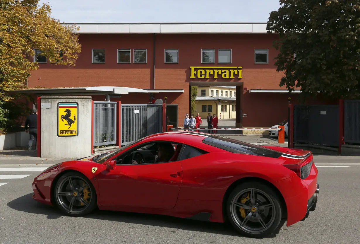 FILE PHOTO: A Ferrari sport car goes past in front of Ferrari's factory in Maranello