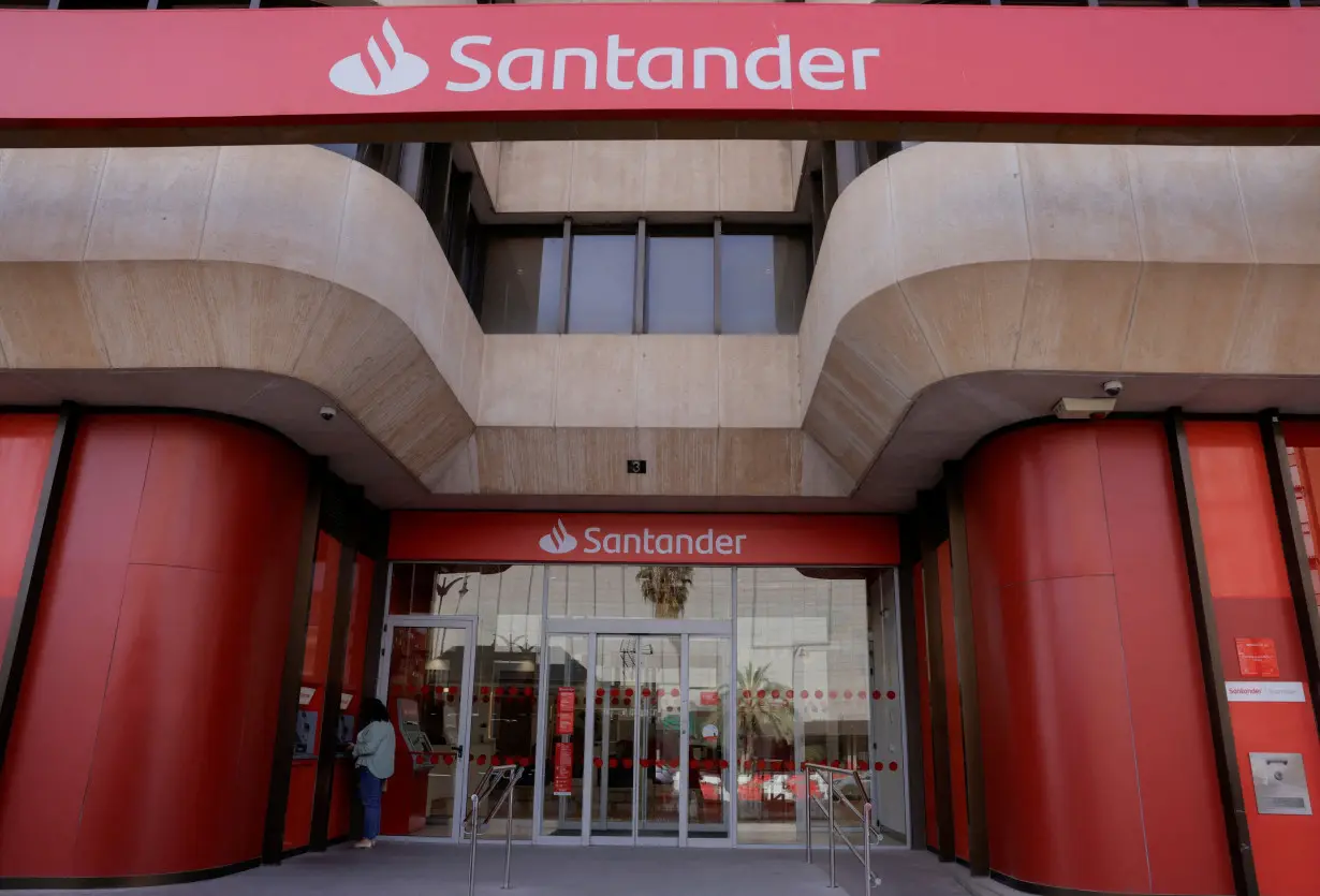 FILE PHOTO: A woman uses an ATM machine at a Santander bank branch office in Malaga