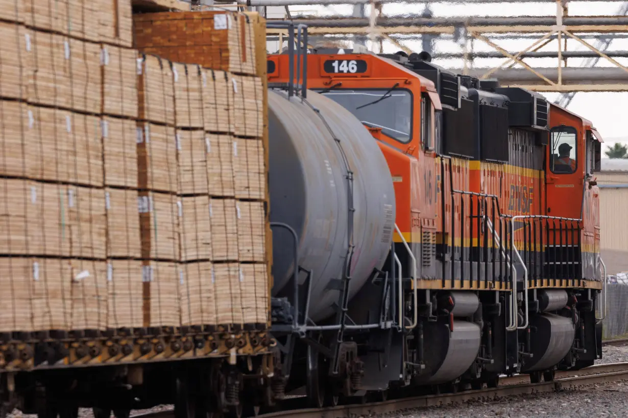 Railway workers load railcars onto train in California