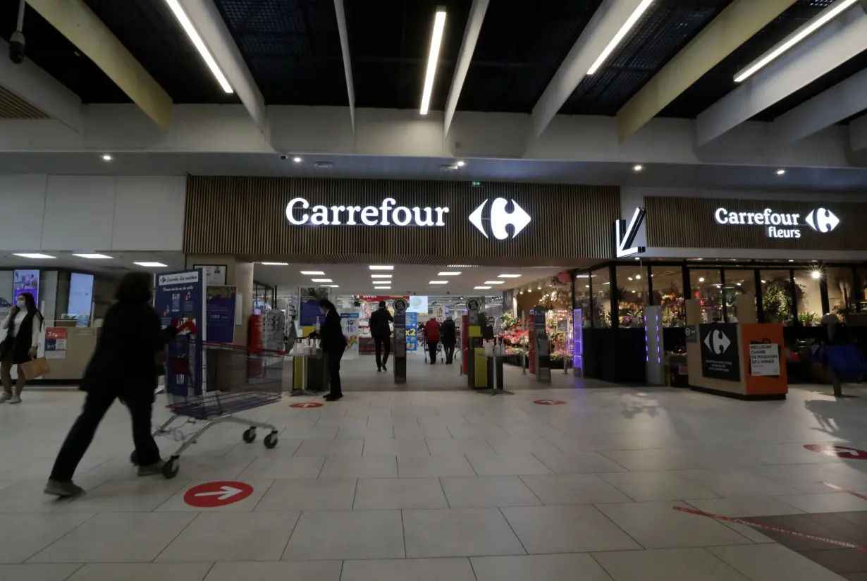 A customer pushes a shopping trolley in a Carrefour Hypermarket store in Nice