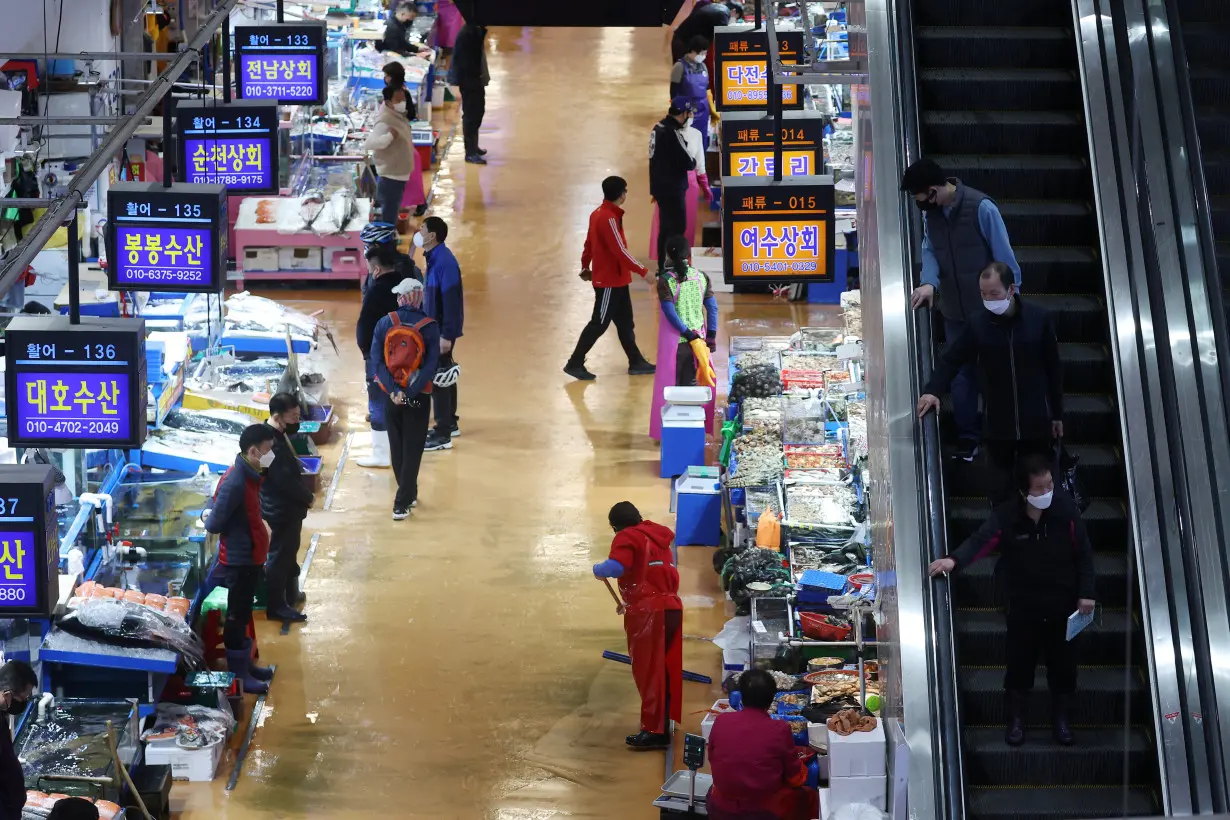 People arrive at Noryangjin Fisheries Wholesale Market, in Seoul