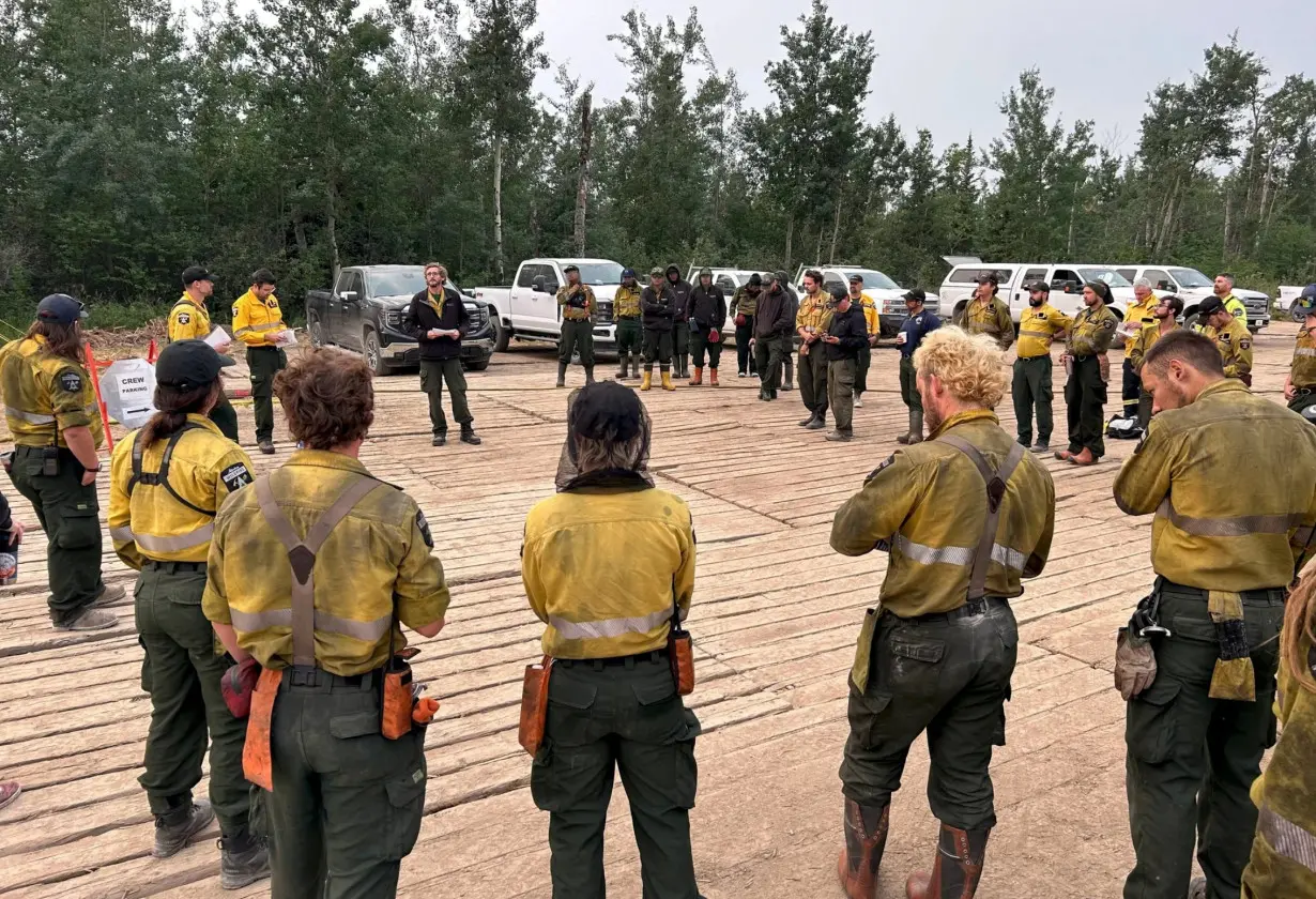 Firefighters receive a morning briefing while battling the Cattail Lake Complex wildfire northeast of Fort McMurray