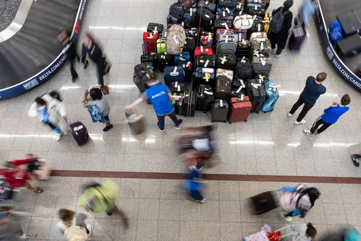 Travelers wait for their luggage at the Delta baggage claim at Hartsfield-Jackson Atlanta International Airport on July 23.