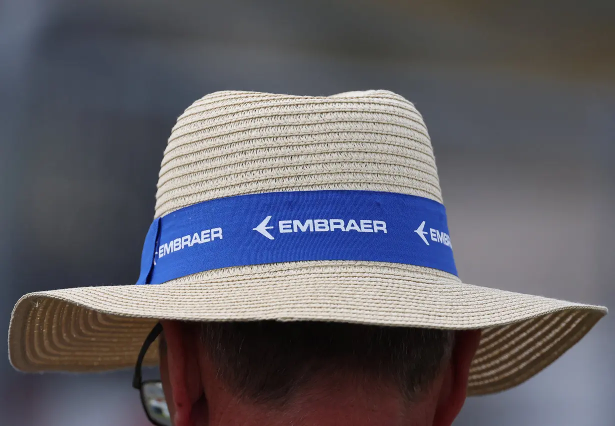 Branding for Embraer is seen on a hat of an attendee at Farnborough International Airshow, in Farnborough