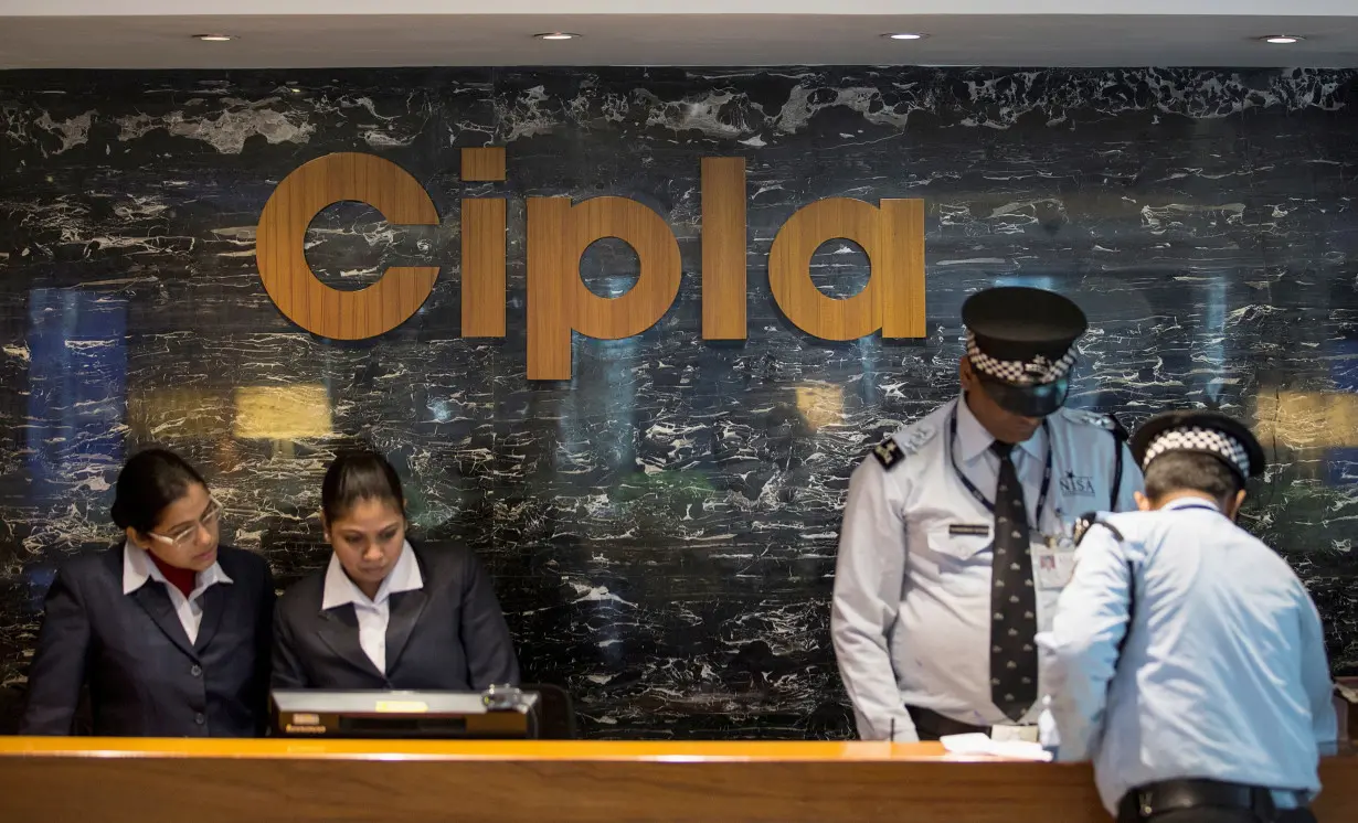 Employees and security staff work at the reception area of Cipla at its headquarters in Mumbai