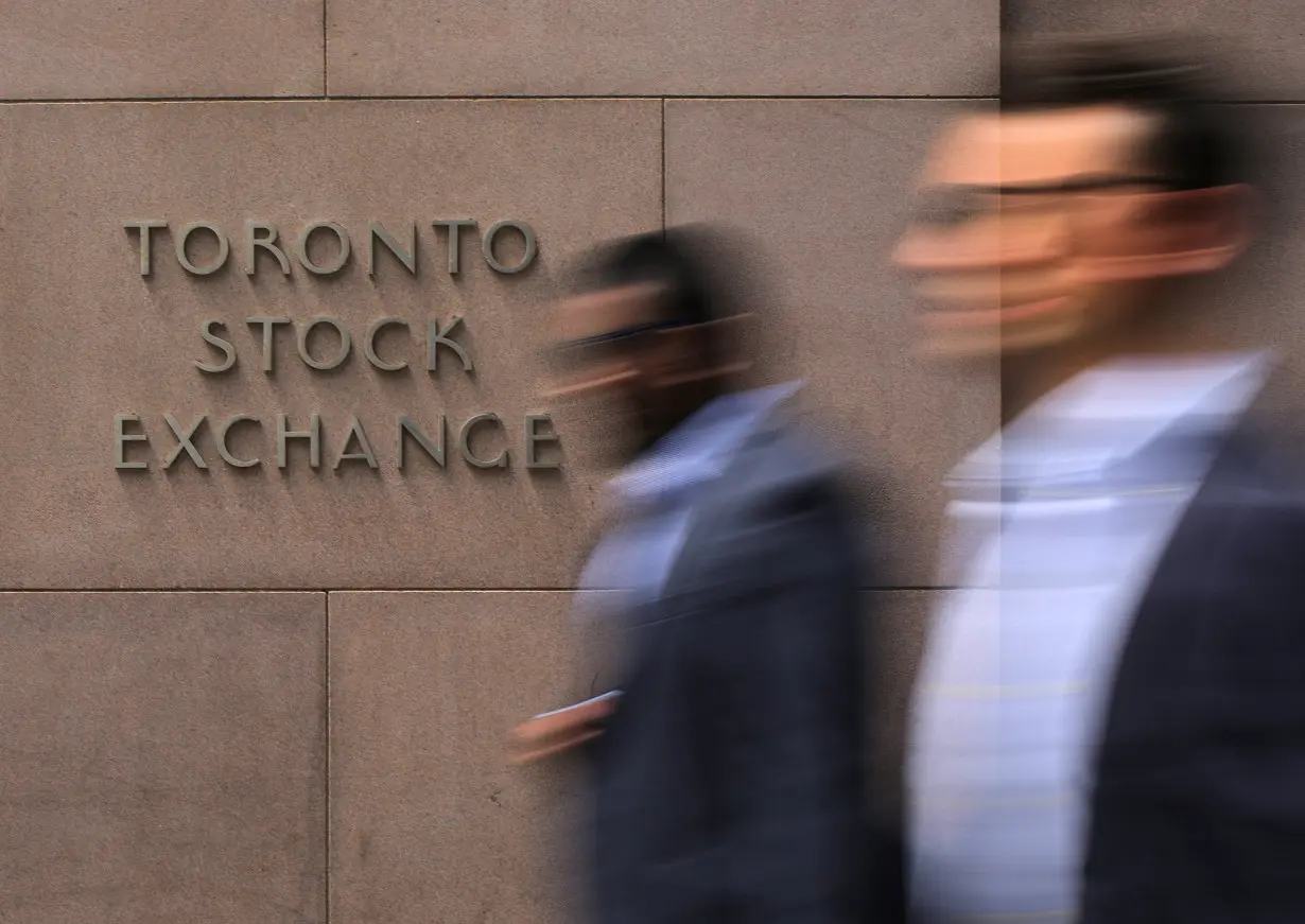 Businessmen pass the Toronto Stock Exchange sing in Toronto