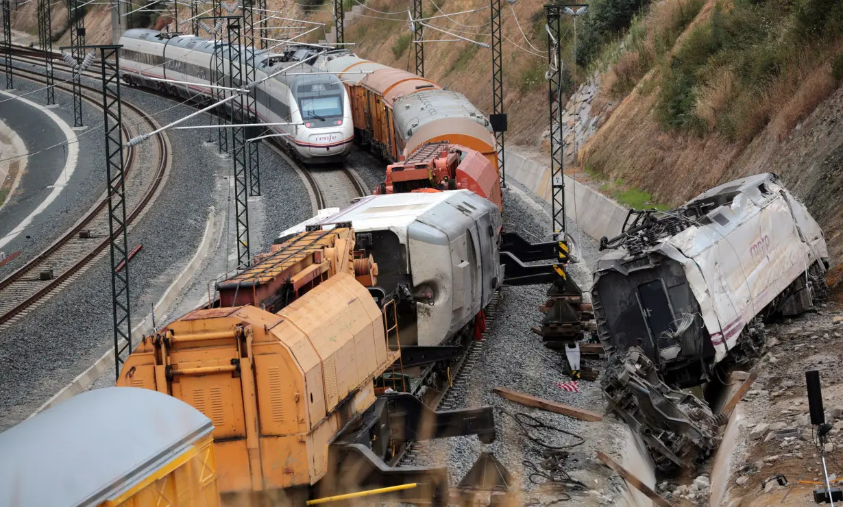 A passenger train drives past the site of a train crash in Santiago de Compostela