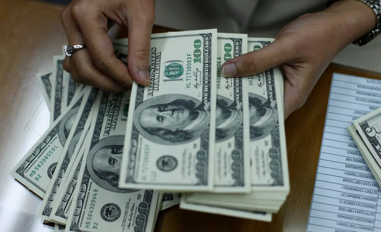 Employee counts U.S. dollar at money changer in Jakarta