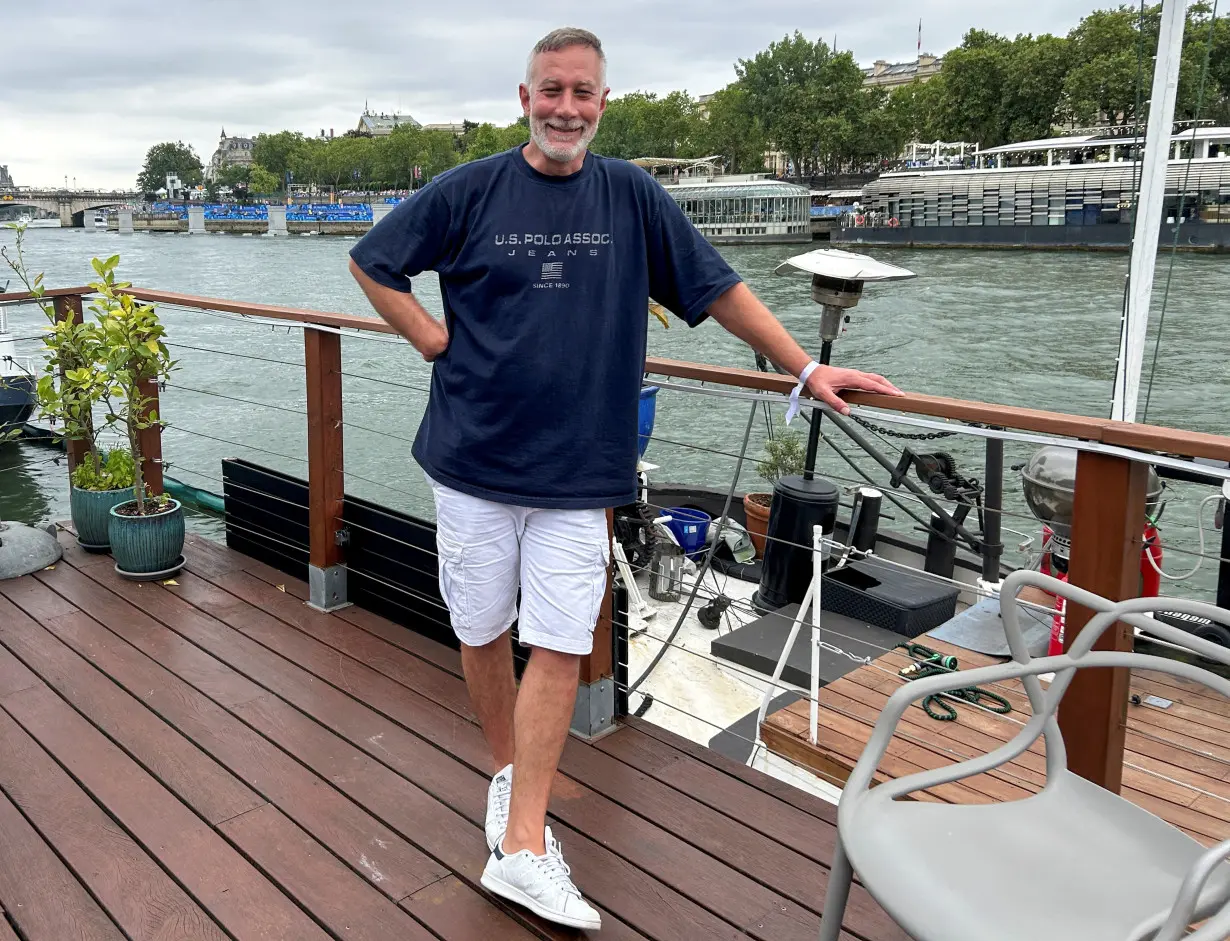 Alexandre Pichot, 48, relaxes on his houseboat along the Seine ahead of the Paris Olympics Opening Ceremony in Paris