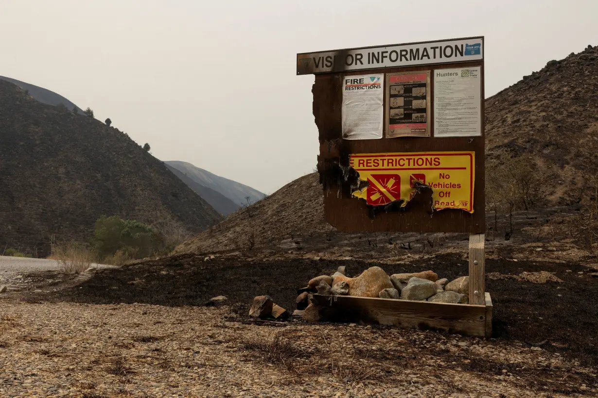 A burned visitor information sign from the Durkee Fire is pictured amid charred hillside near Huntington, Oregon, U.S., July 27.