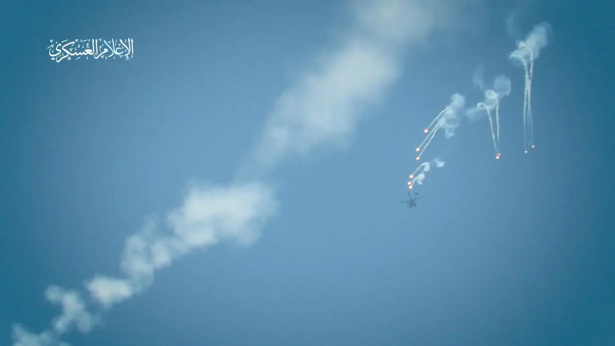 An Israeli military helicopter releases flares, amid the Israel-Hamas conflict, at a location given as Gaza