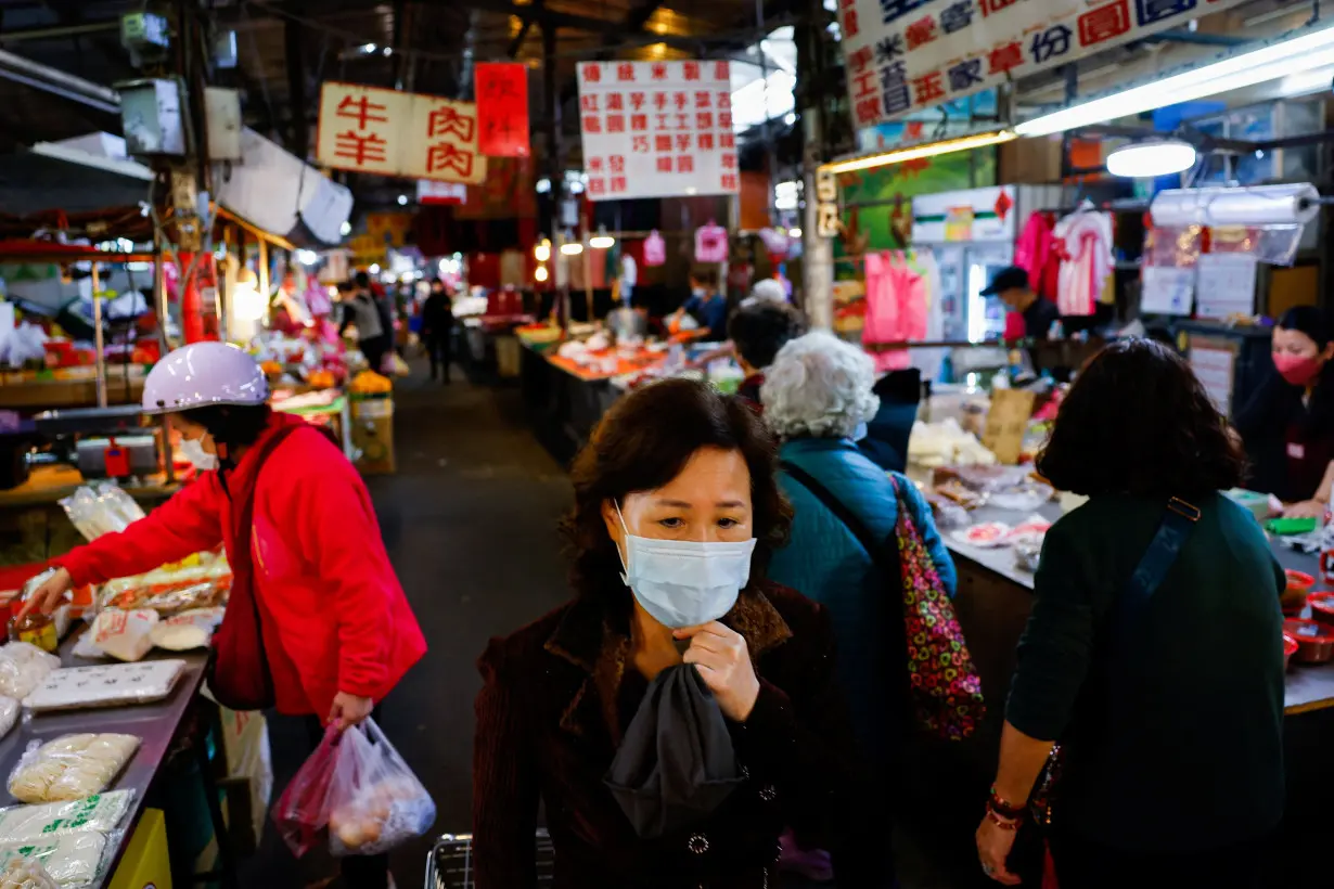 People buy food items at a market in New Taipei City