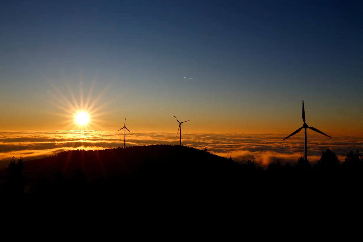 A wind turbine stands out against the sky as the sun sets over the Black Forest Brandenkopf lookout