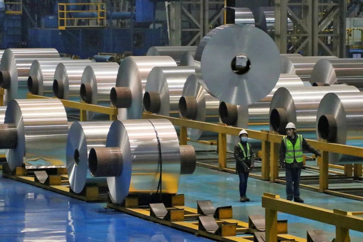 FILE PHOTO: Employees work at the production line of aluminium rolls at a factory in Zouping, Shandong province, China