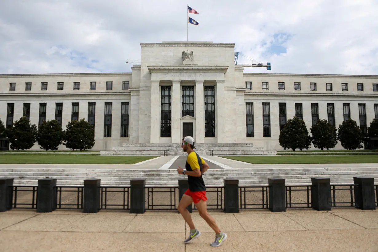 FILE PHOTO: A jogger runs past the Federal Reserve building in Washington, DC