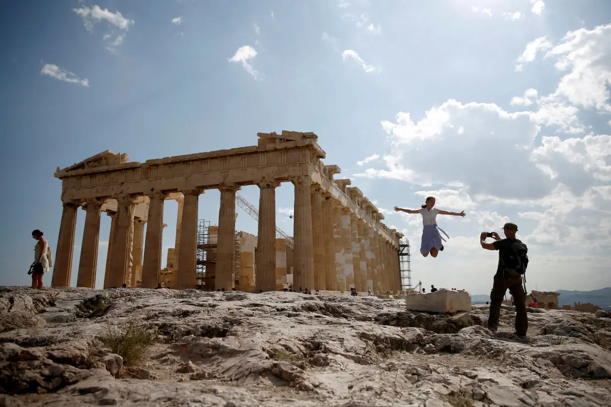 FILE PHOTO: Tourists take a picture in front of the temple of the Parthenon atop the Acropolis in Athens