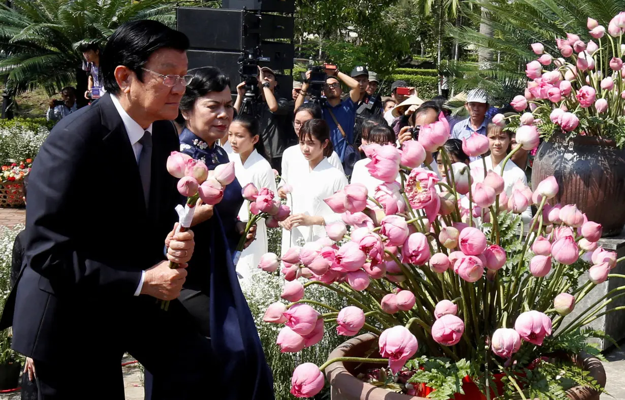 FILE PHOTO: Former Vietnamese President Truong Tan Sang and his wife Mai Thi Hanh lay flower during the 50th anniversary of the My Lai massacre in My Lai village