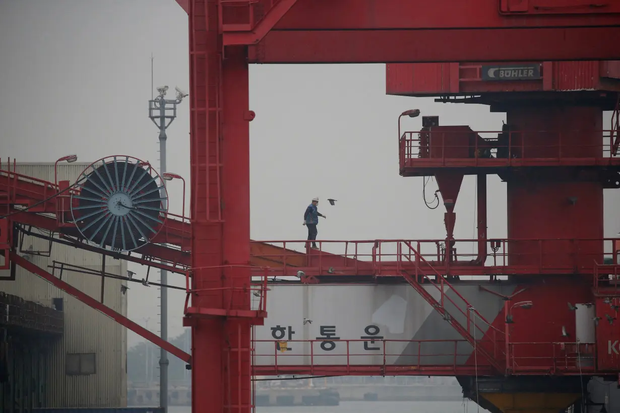 FILE PHOTO: An employee walks on a crane at a container terminal at Incheon port in Incheon