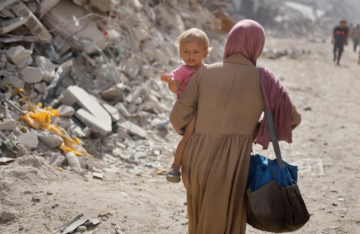 Palestinians make their way to return to neighbourhoods after Israeli forces pulled out from the eastern side of Khan Younis, in Khan Younis, in the southern Gaza Strip