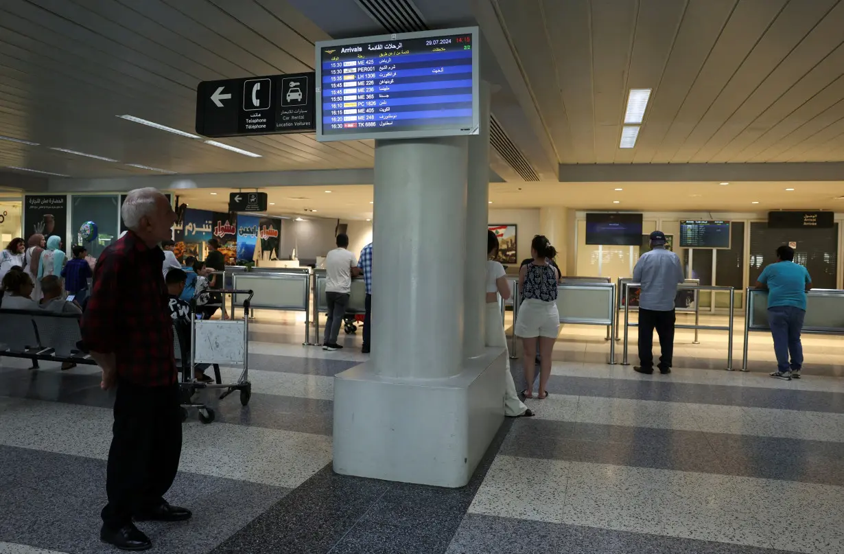 A man checks a flight information board showing a cancelled flight at the Beirut–Rafic Hariri International Airport, in Beirut