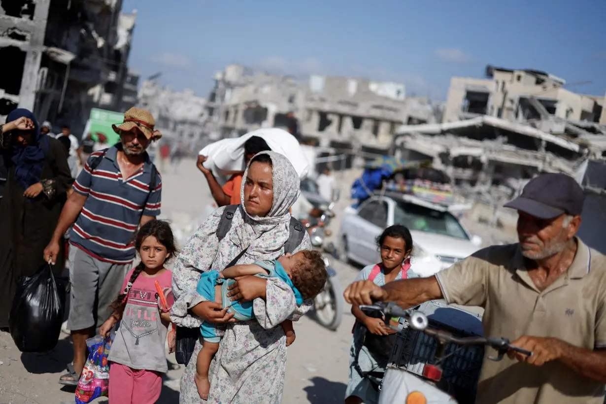 Palestinians make their way to return to neighbourhoods after Israeli forces pulled out from the eastern side of Khan Younis, in Khan Younis, in the southern Gaza Strip