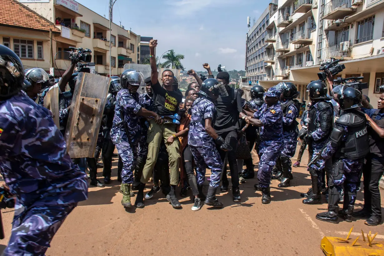 Demonstrators are detained by police after trying to reach the Ugandan Parliament during an anti-corruption march in Kampala on 23 July.