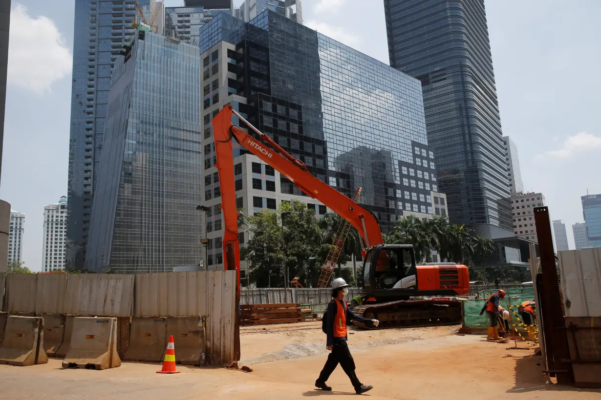 FILE PHOTO: A worker walks near The Jakarta Mass Rapid Transit construction at Sudirman Business District in Jakarta