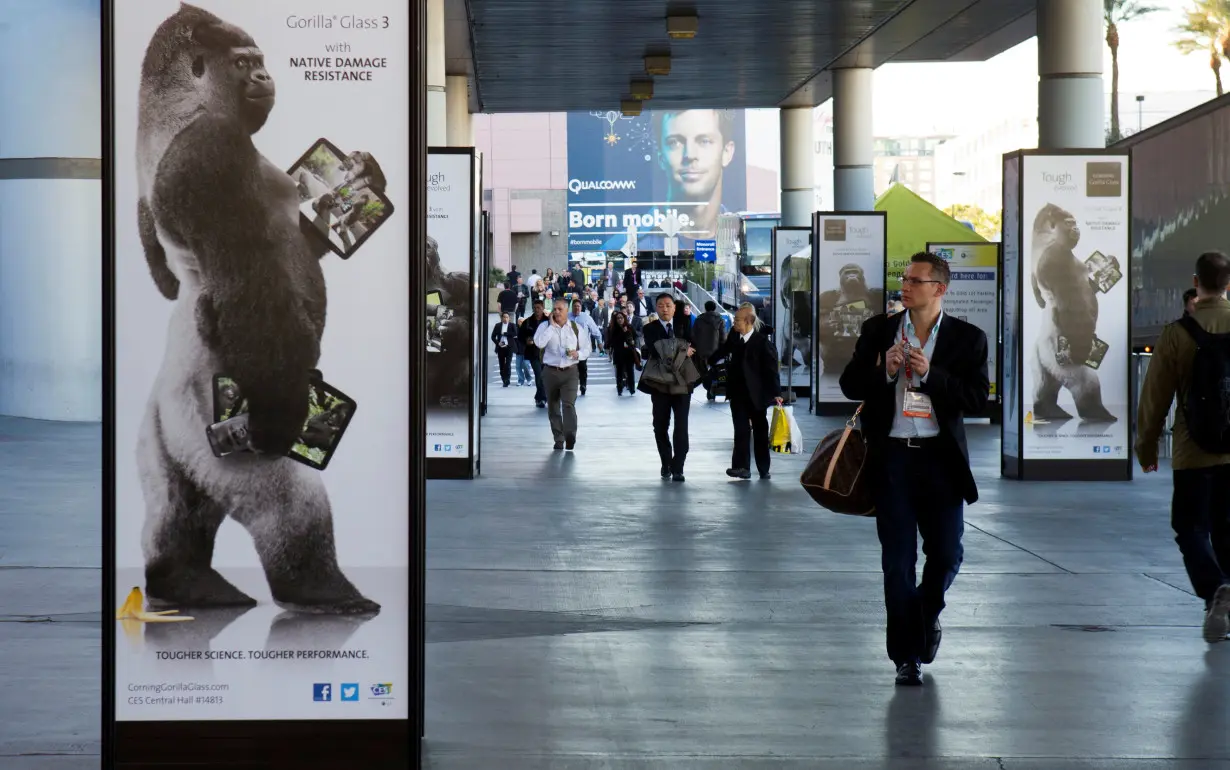 FILE PHOTO: Man walks by advertisement for Corning Gorilla Glass 3 outside Las Vegas Convention Center on first day of Consumer Electronics Show in Las Vegas