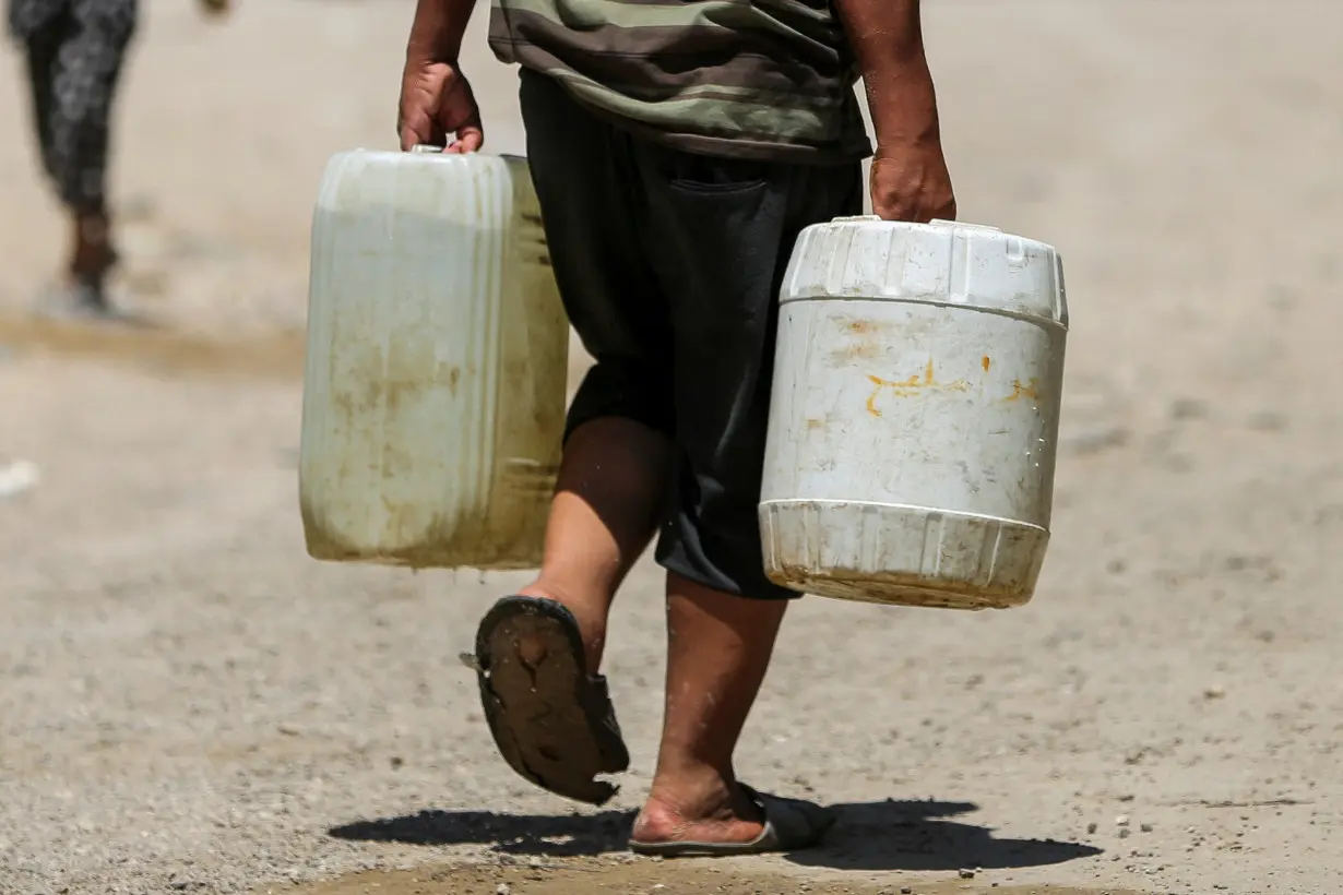 Palestinians gather to collect water amid shortages in Khan Younis in the southern Gaza Strip