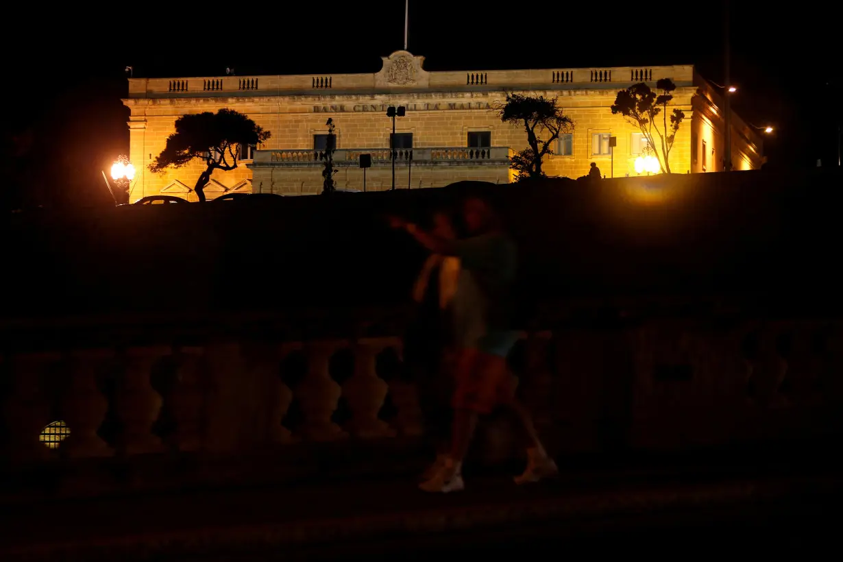 FILE PHOTO: People walk past the Central Bank of Malta as the government's 2019 budget is presented in parliament in Valletta