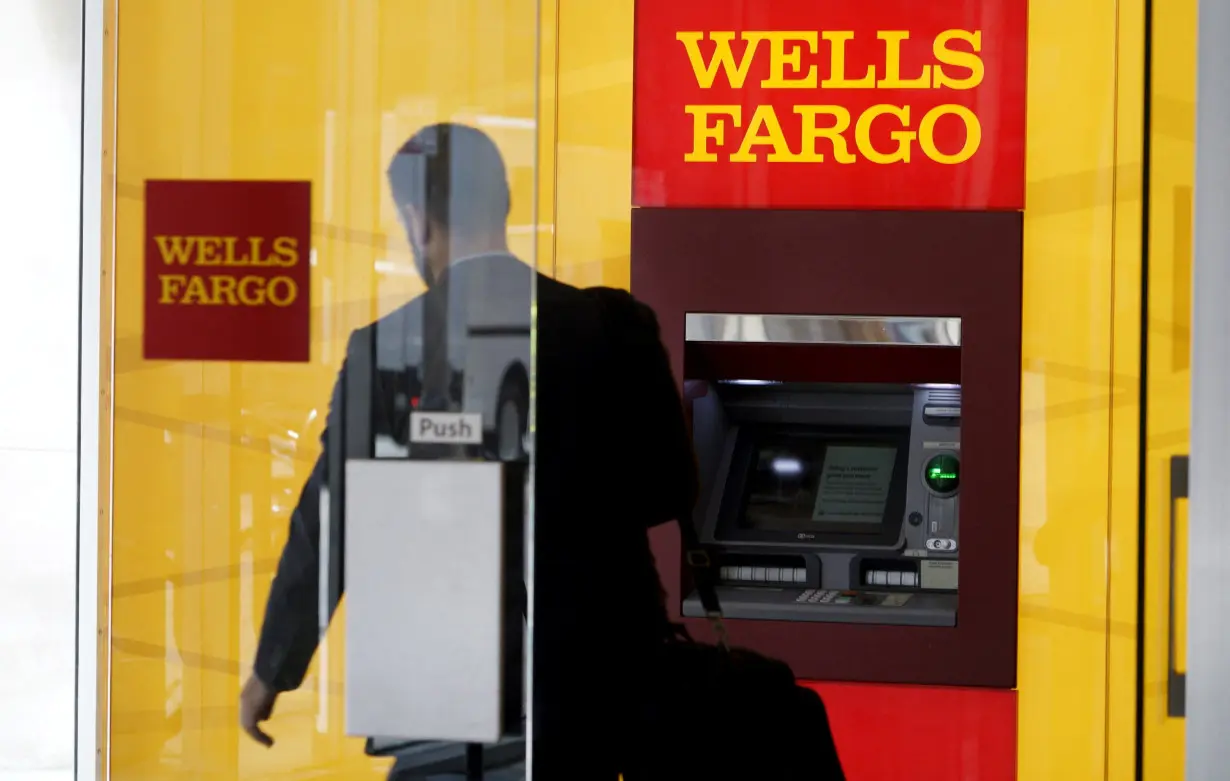 FILE PHOTO: A man walks by an ATM at the Wells Fargo & Co. bank in downtown Denver