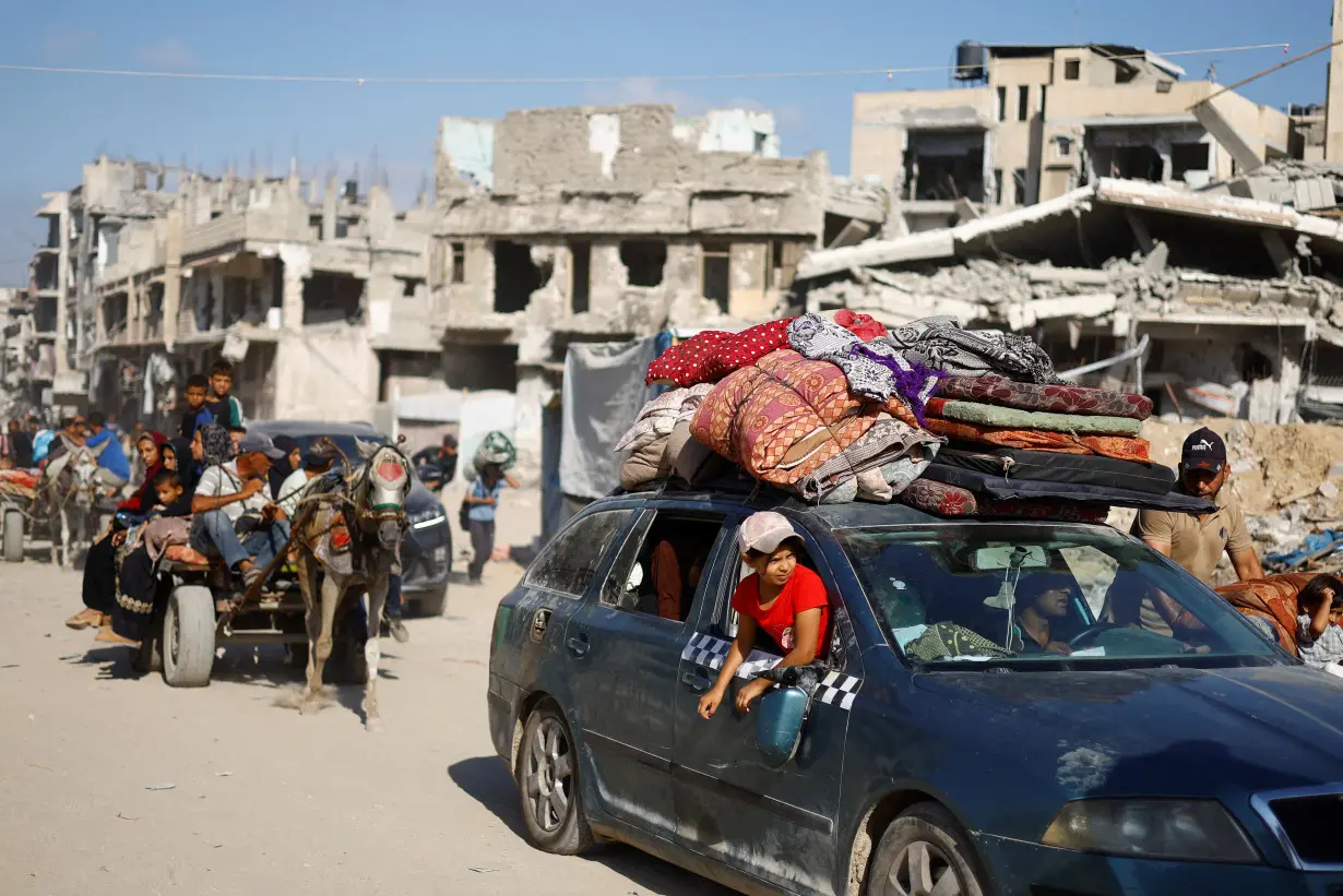 Palestinians make their way to return to neighbourhoods after Israeli forces pulled out from the eastern side of Khan Younis, in Khan Younis, in the southern Gaza Strip