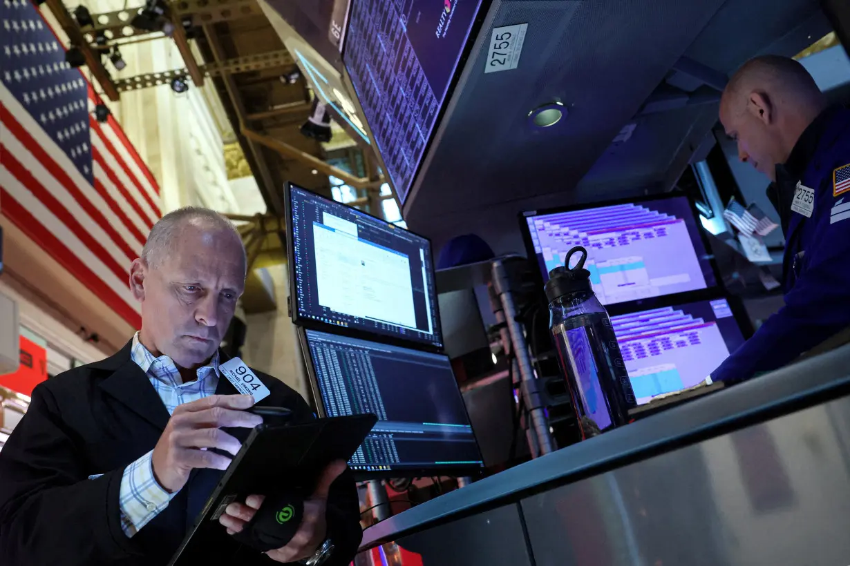 FILE PHOTO: Traders work on the floor of the NYSE in New York