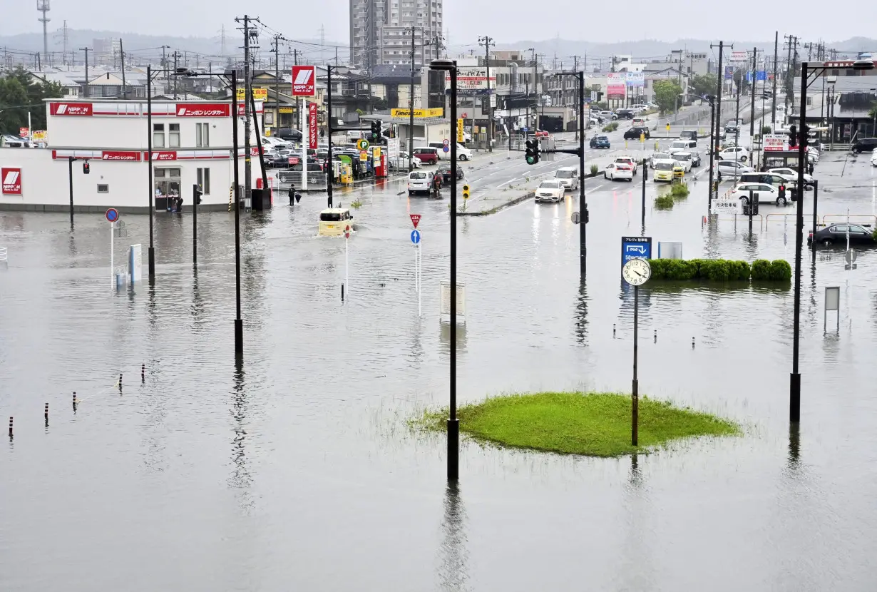 Roads in front of Akita station are flooded following heavy rain in Akita