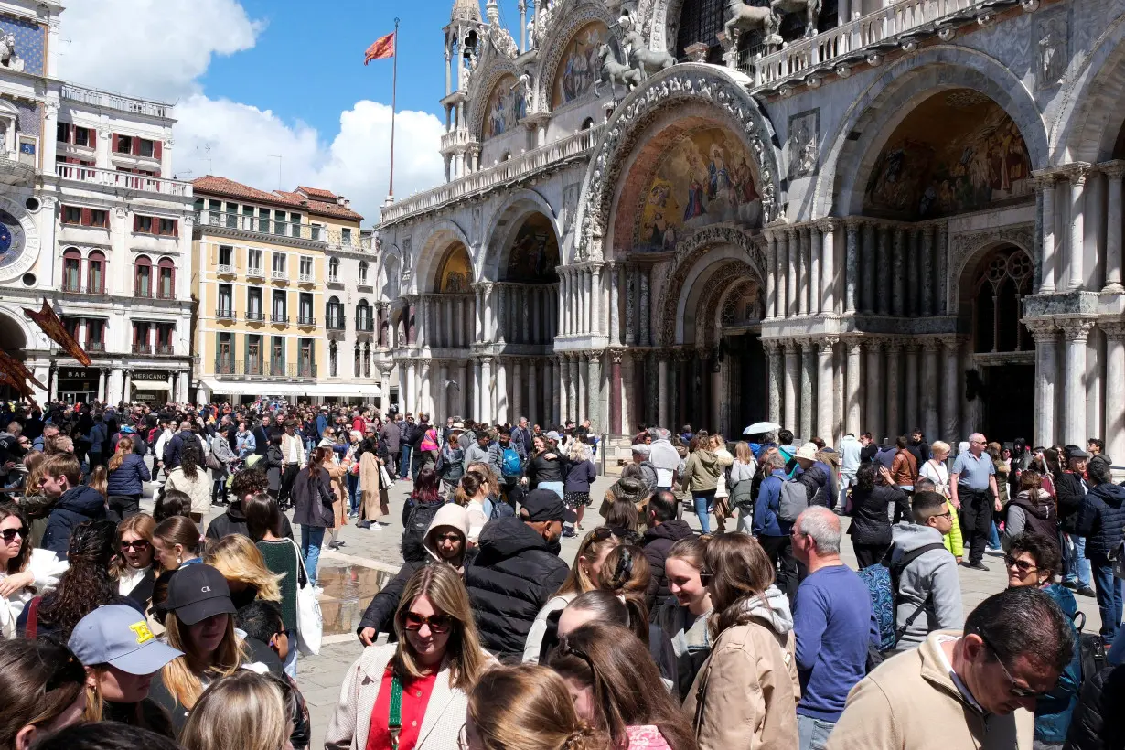 FILE PHOTO: Tourists walk in St Mark's Square on the day Venice municipality introduces a new fee for day