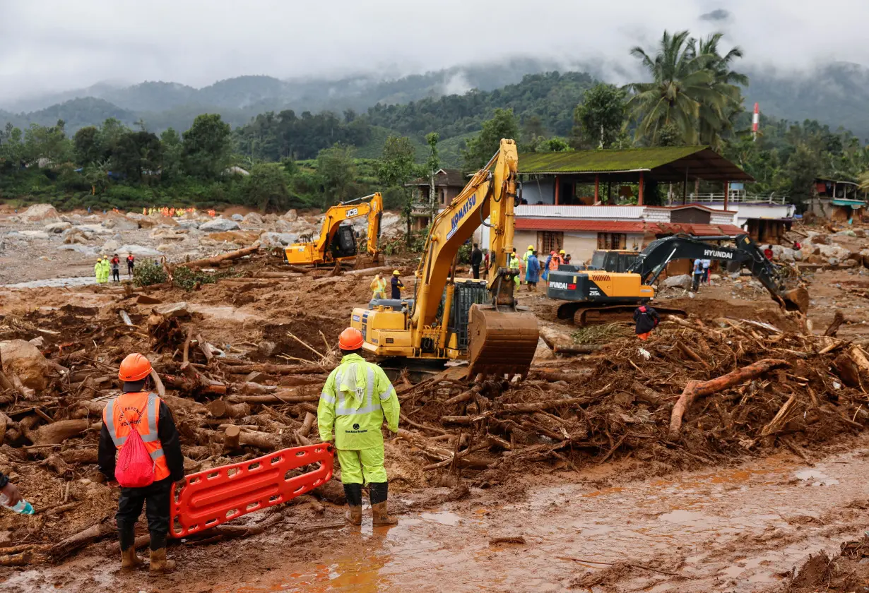 Rescuers hold a stretcher as the search for survivors continues after several landslides hit the hills in Wayanad district, in Kerala