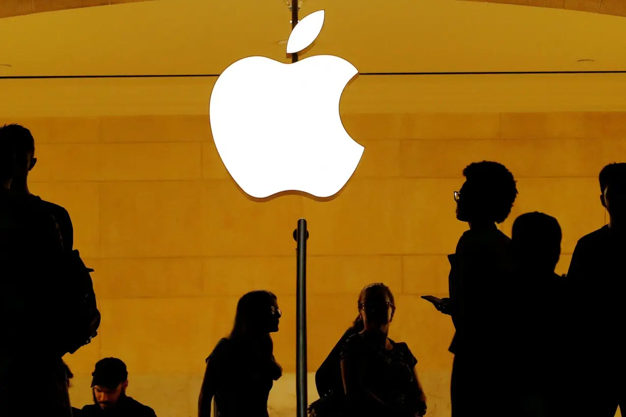 FILE PHOTO: Customers walk past an Apple logo inside of an Apple store at Grand Central Station in New York