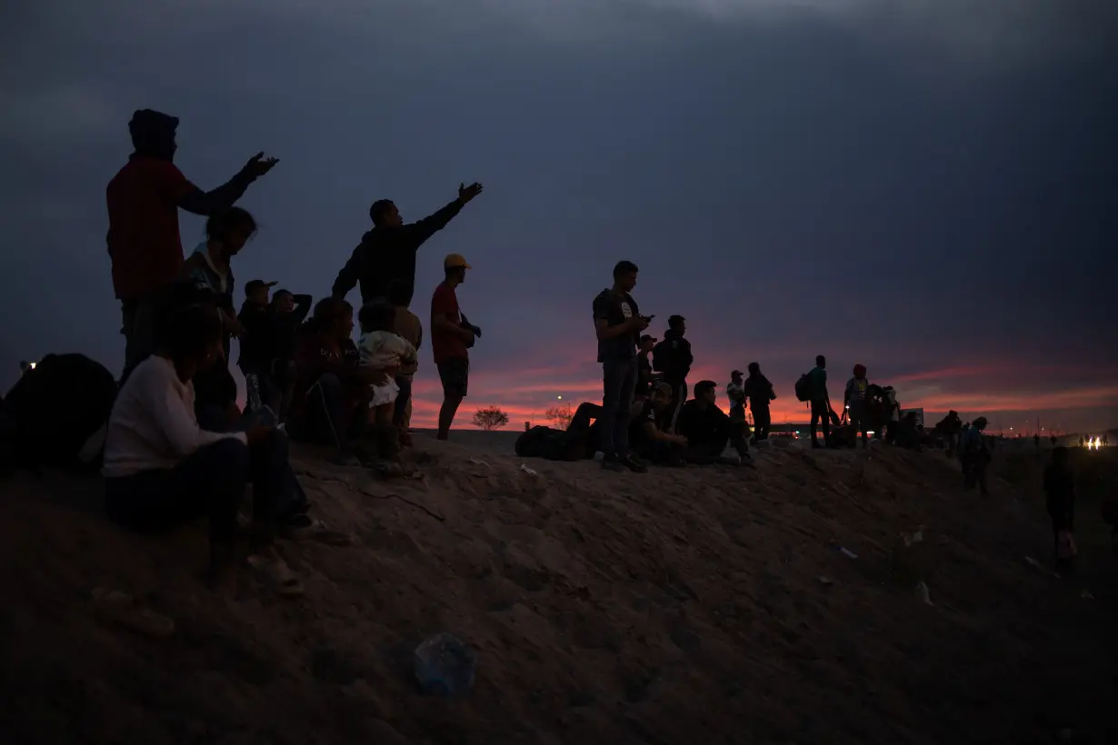 Migrant point towards the United States from the bank of Rio Grande river in Ciudad Juarez