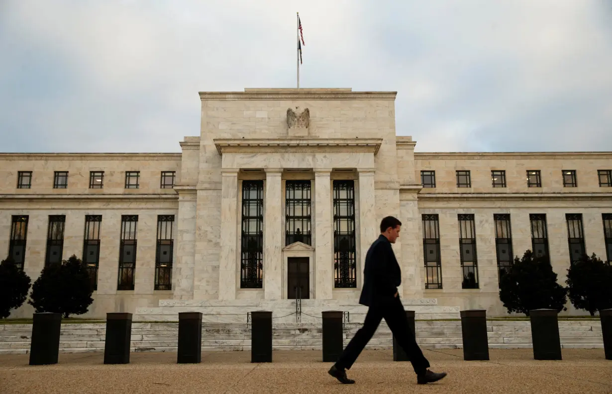 FILE PHOTO: A man walks past the Federal Reserve in Washington