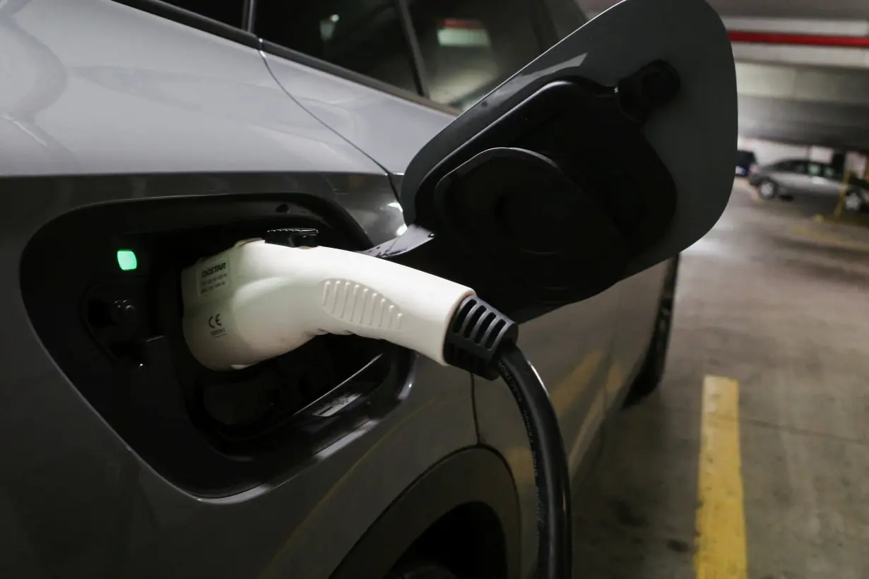 FILE PHOTO: A charging handle recharges an electric vehicle parked at a charging station in Baltimore