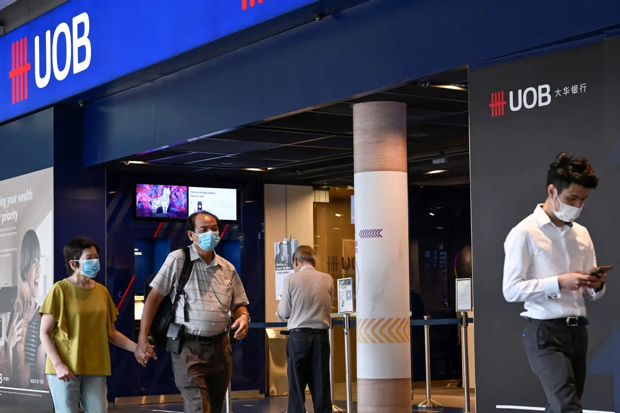 People walk past a United Overseas Bank branch in Singapore