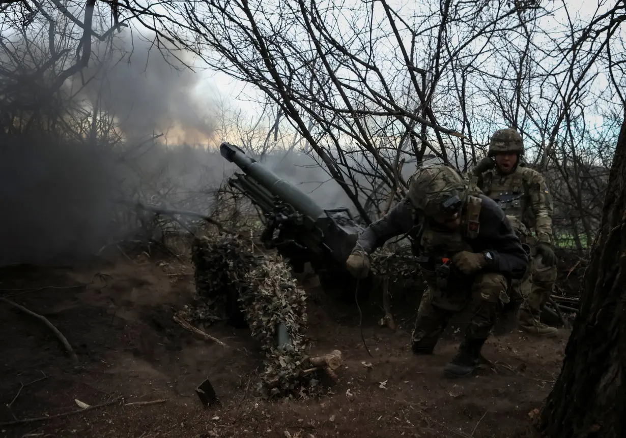 Servicemen of the National Guard of Ukraine fire a howitzer towards Russian troops in Donetsk region