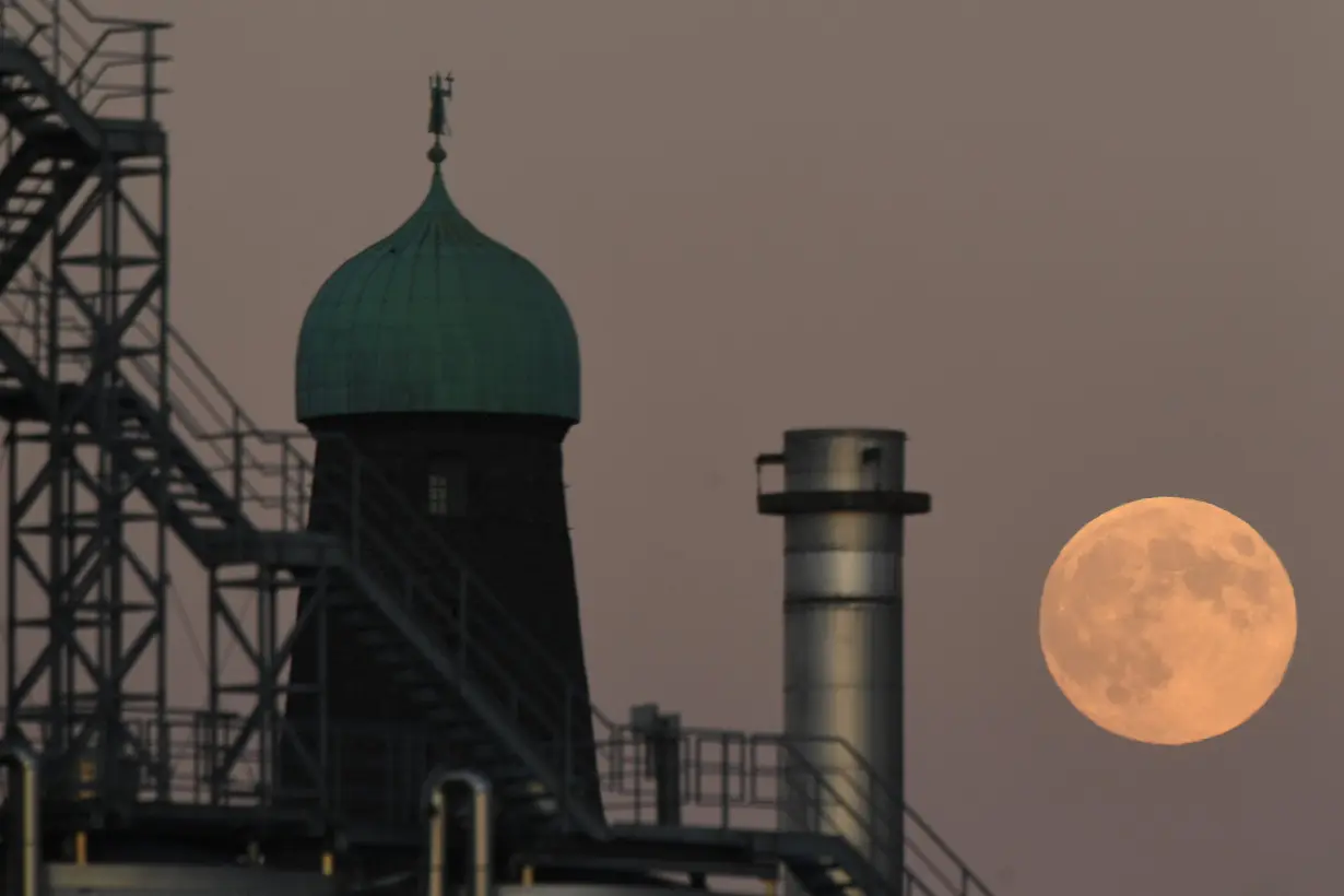 A strawberry moon is seen over chimneys at the Guinness factory during sunset in Dublin