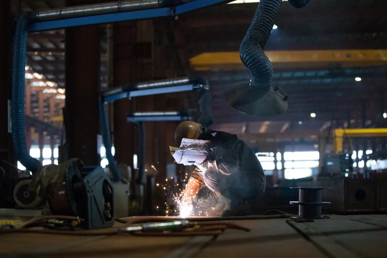 Employee works at a steel processing production line at a factory in Hefei