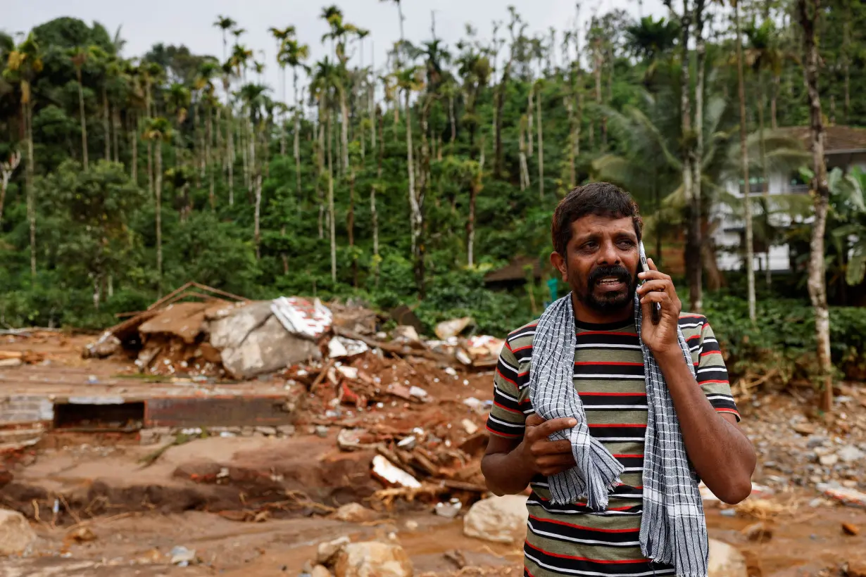 A man cries as he speaks to relatives after his home and auto rickshaw was destroyed after multiple landslides hit the hills in Wayanad district, in the southern state of Kerala