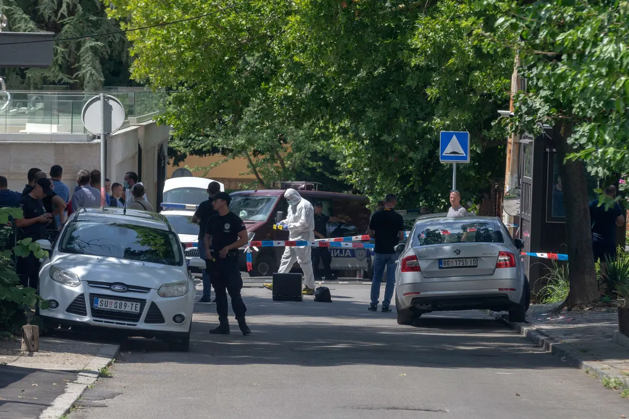 Police officers work at the crime scene close to the Israeli embassy in Belgrade on June 28.