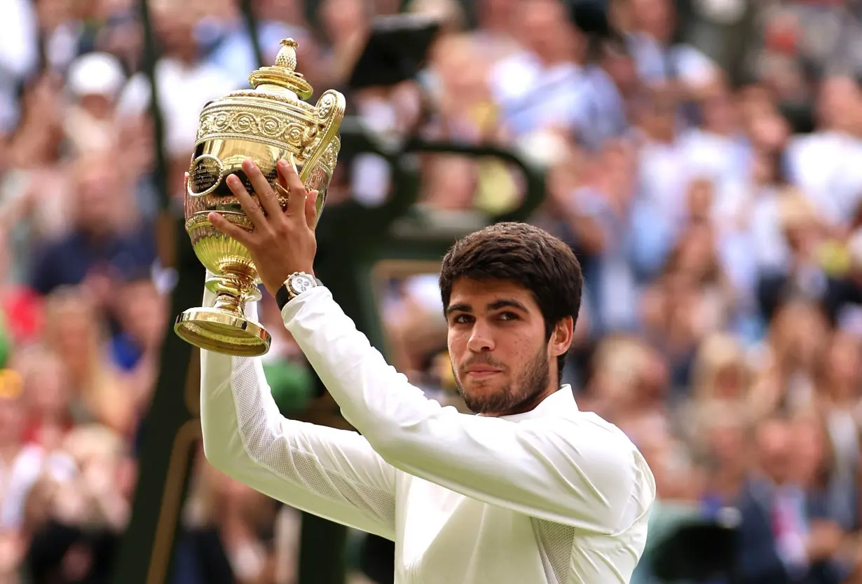 Carlos Alcaraz lifts the men's singles trophy at Wimbledon in 2023.