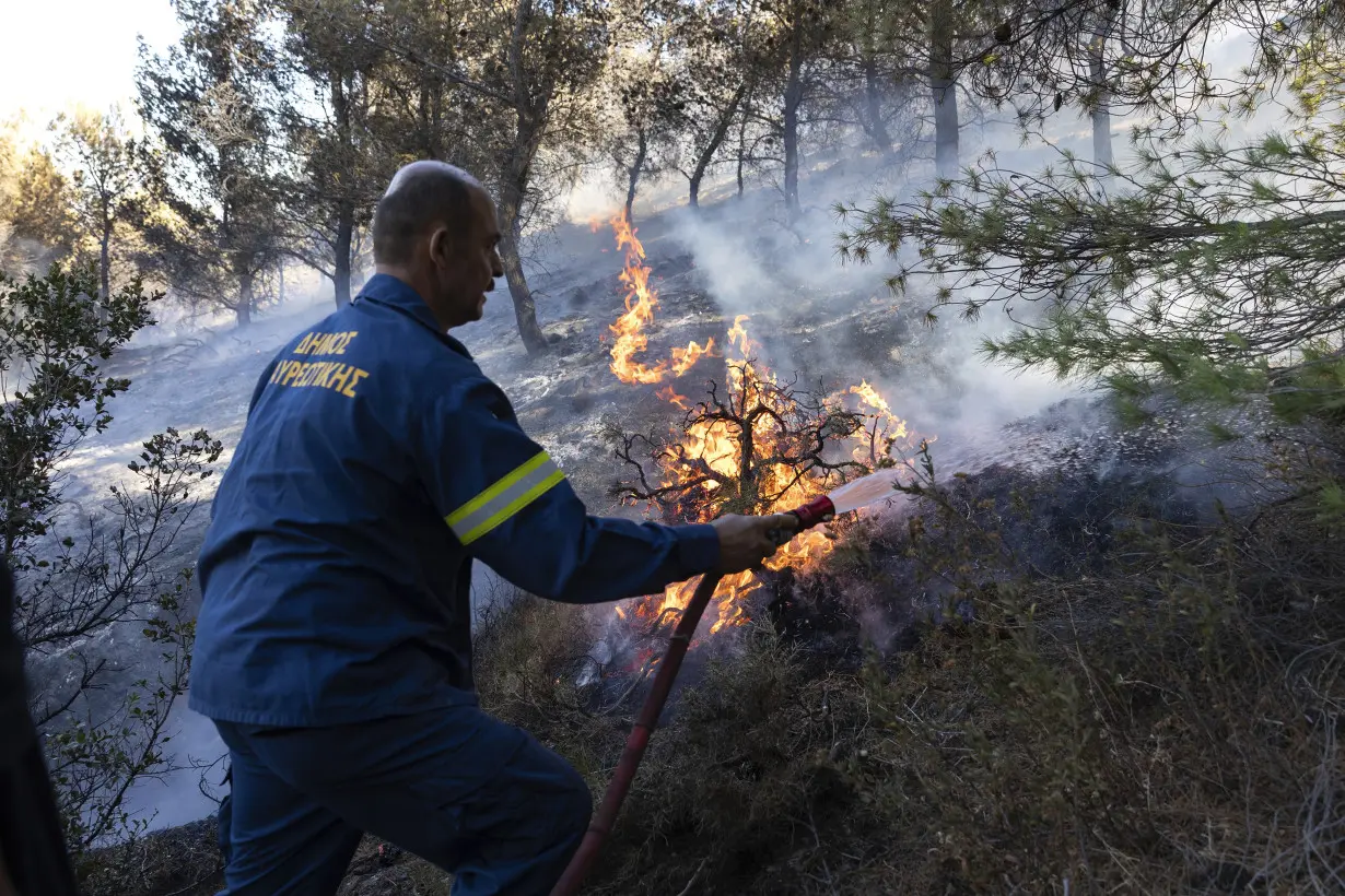 Firefighters battle wildfires on 2 Greek islands as premier warns of a dangerous summer