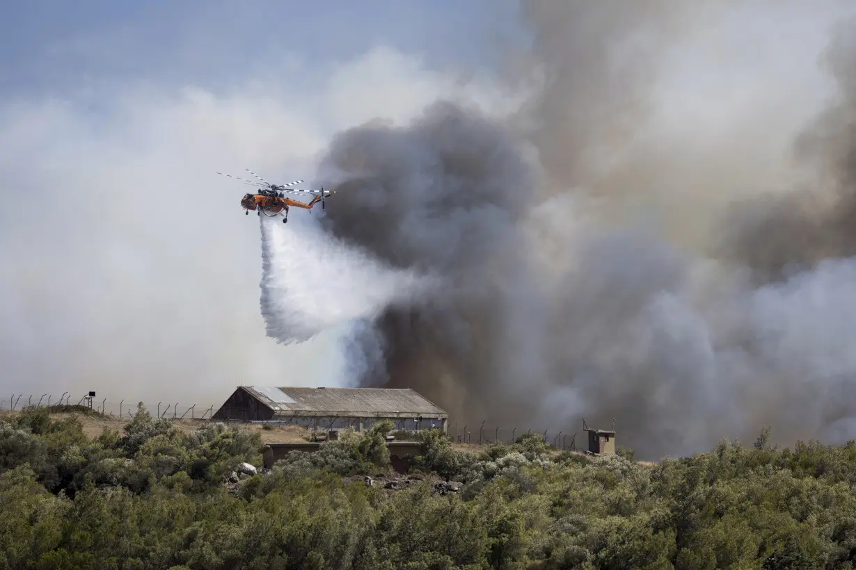 Firefighters battle wildfires on 2 Greek islands as premier warns of a dangerous summer