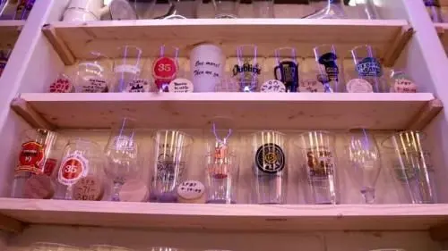 Hundreds of drinking glasses from pints to snifters to tasters are strategically placed on shelves lining the walls by Michael Smith's personal bar.